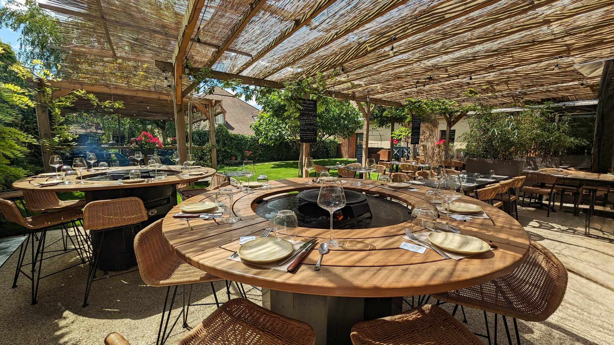 Les grandes tables brasero dans le jardin du Bistro